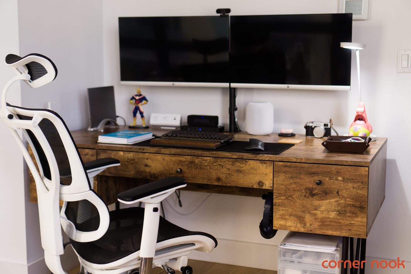 Eurotech iOO mesh chair with a white frame at a wooden desk beneath two monitors