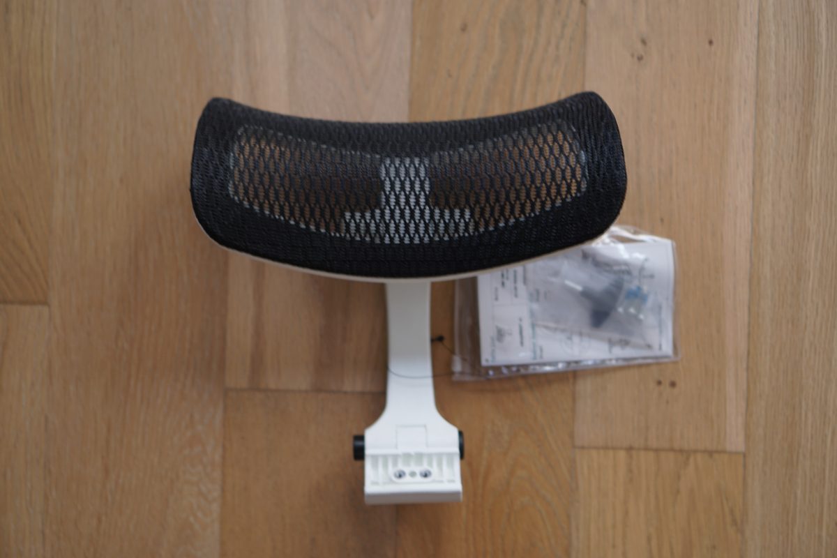 The Eurotech iOO mesh headrest on a wood floor beside its bag of hardware