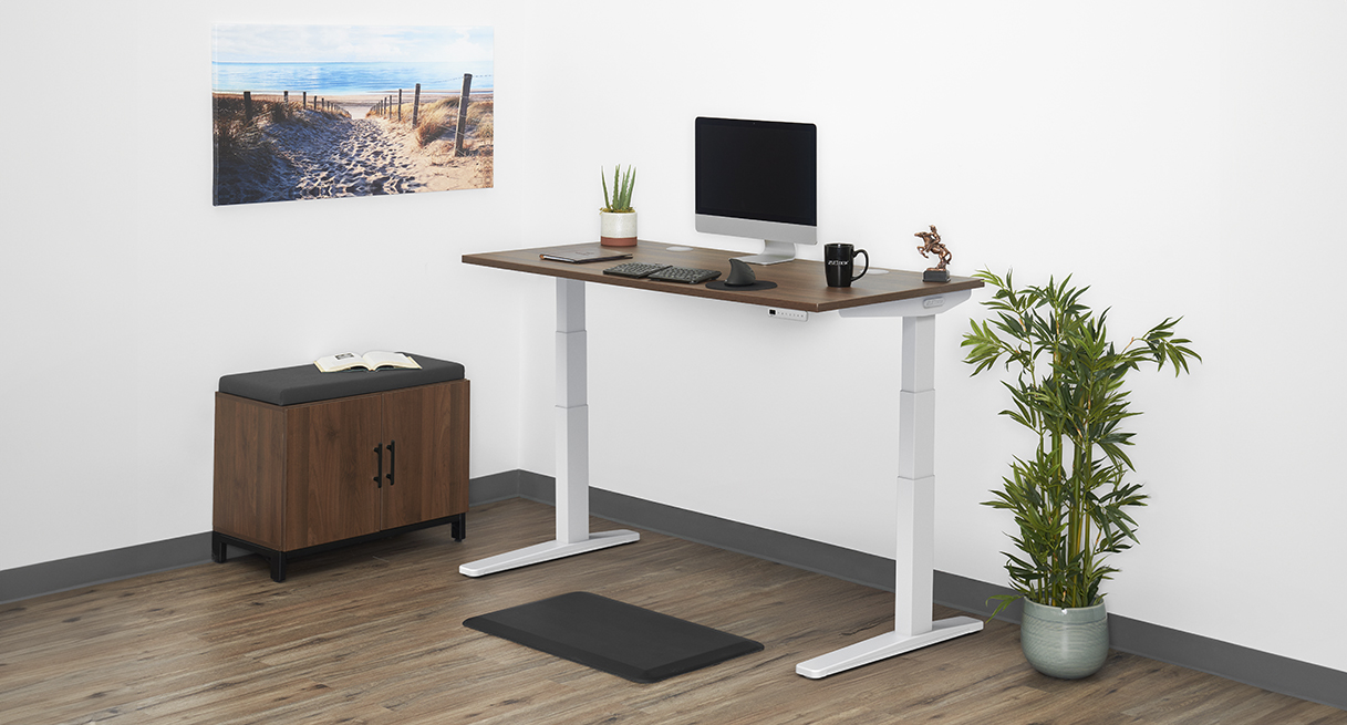 Uplift V3 standing desk with a white frame and a walnut top in a home office
